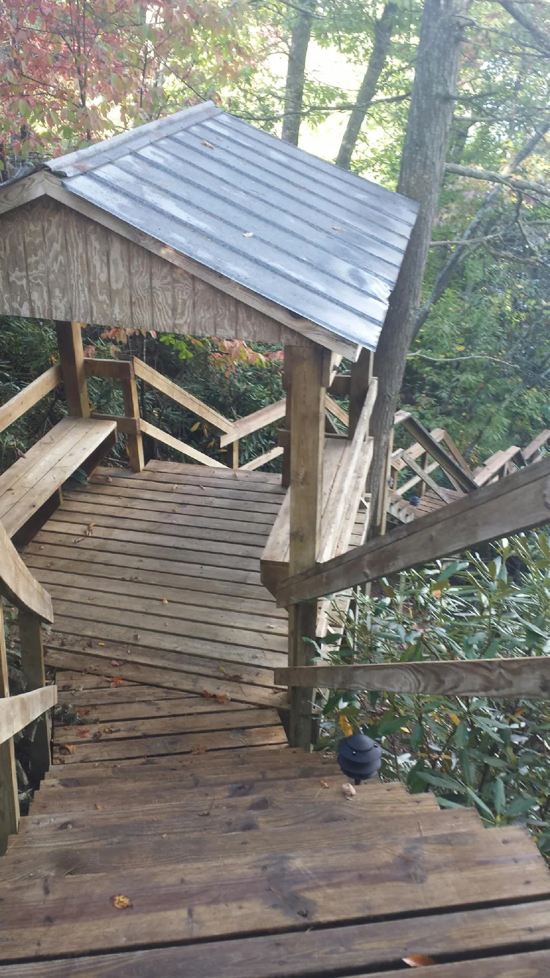 Metal roofed shelter over wooden steps on a wooded walkway — Skylight Repair & Installation work by our crew in Eaton Center