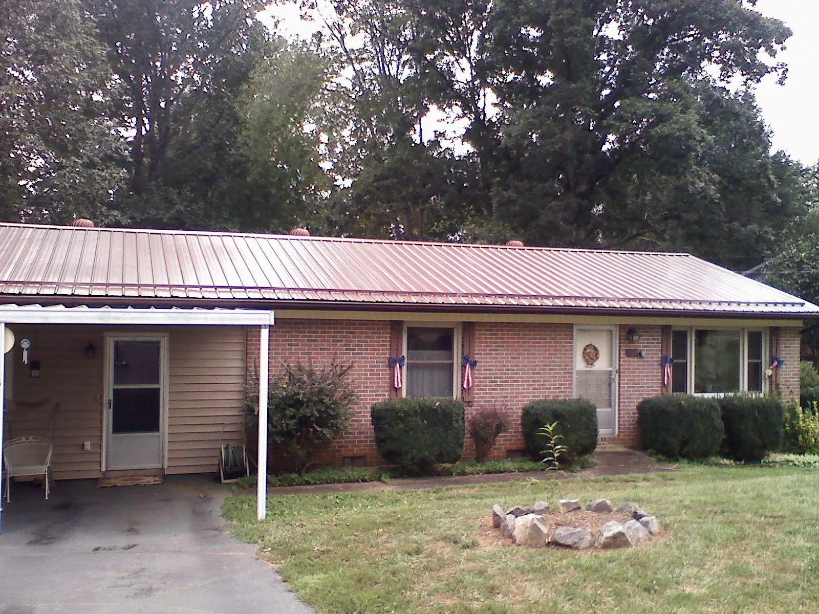 Bronze metal roof and carport on a brick ranch home — Roof Repair work by our crew in Eaton Center